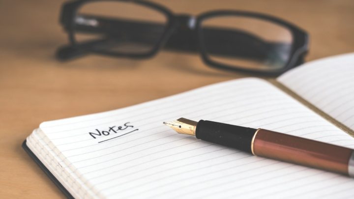 Caderno, caneta e óculos sobre a mesa